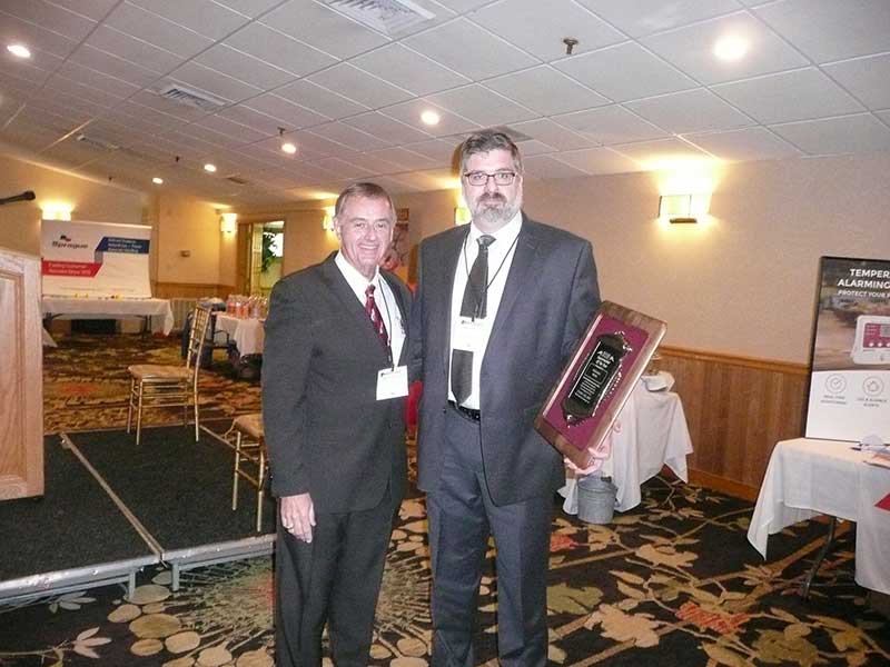 NHGA President John Dumais presents the Supermarket of the Year Award to Ed Penta of McKinnon's Market.