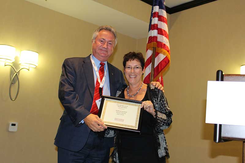 NECSEMA Executive Director Joanne Mendes posthumously inducts Wilfred Iandoli of Honey Farms into the Hall of Fame. Dave Murdock accepts the award.