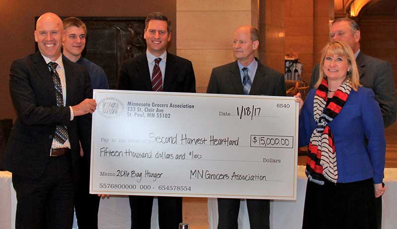 The 2016 Bag Hunger Campaign donation was made to Rob Zeaske, CEO of Second Harvest Heartland (far left), by Jamie Pfuhl, president of the Minnesota Grocers Association (far right).