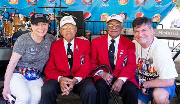 Elaine Rogers, president of USO of Metropolitan Washington-Baltimore, and Gordon Reid, president of Giant Food of Landover, right, celebrate the opening of the 25th Annual Giant National Capital Barbecue Battle with Walter Robinson Jr. and William Fauntroy Jr., two Tuskegee Airmen who served during World War II. 