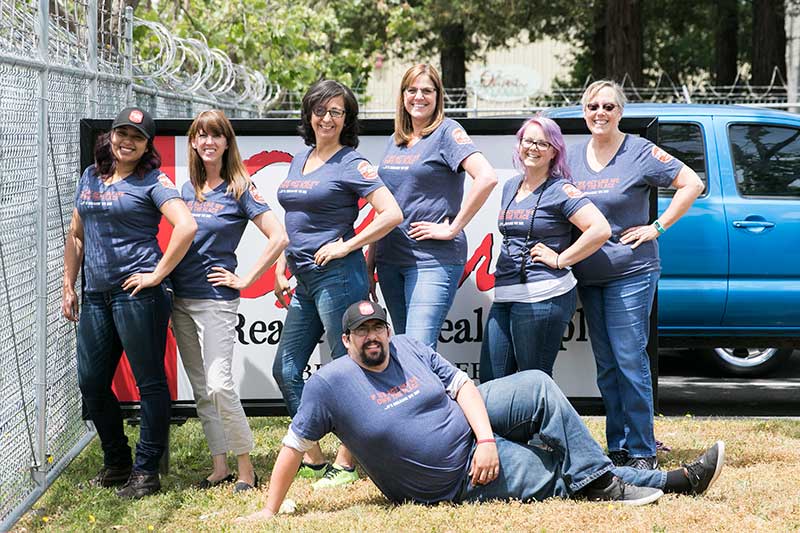 Oliver’s HR team sporting celebratory t-shirts. They read “If we act like we own the place, it’s because we do!”