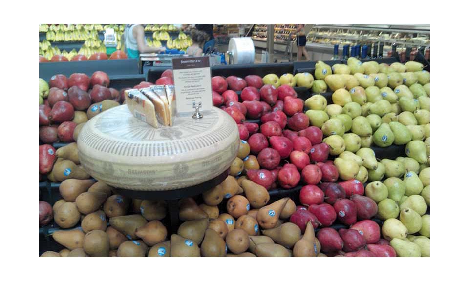 A produce department displaying cheese with the fruit