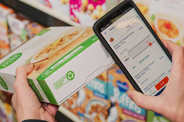 A woman scanning a cereal box with her smartphone