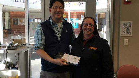 Jen Tomer, team leader of VERC East Acton Mobil, presents a check for $500 to Andrew Shen, principal of R.J. Grey Junior High School in Acton.