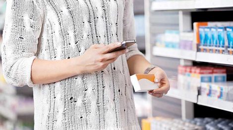 A shopper using her smart phone in-store.