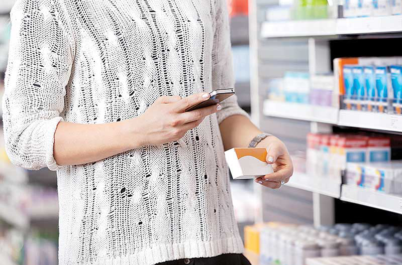 A shopper using her smart phone in-store.