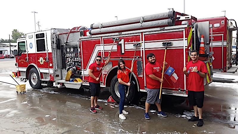 H-E-B employees washing a fire truck