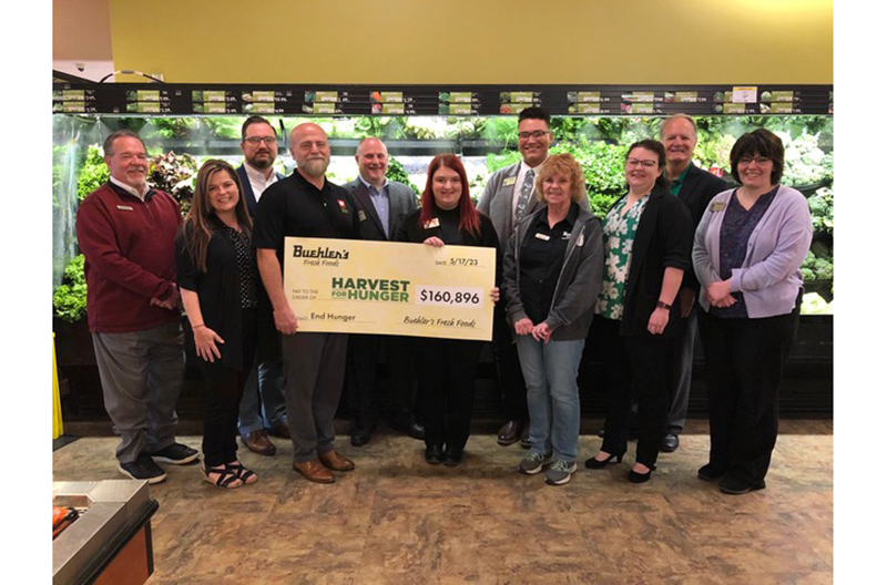 Buehler's Fresh Food employees holding Harvest for Hunger check