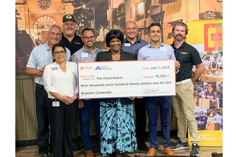 Representatives from The Food Depot and Albertsons Markets hold a check.