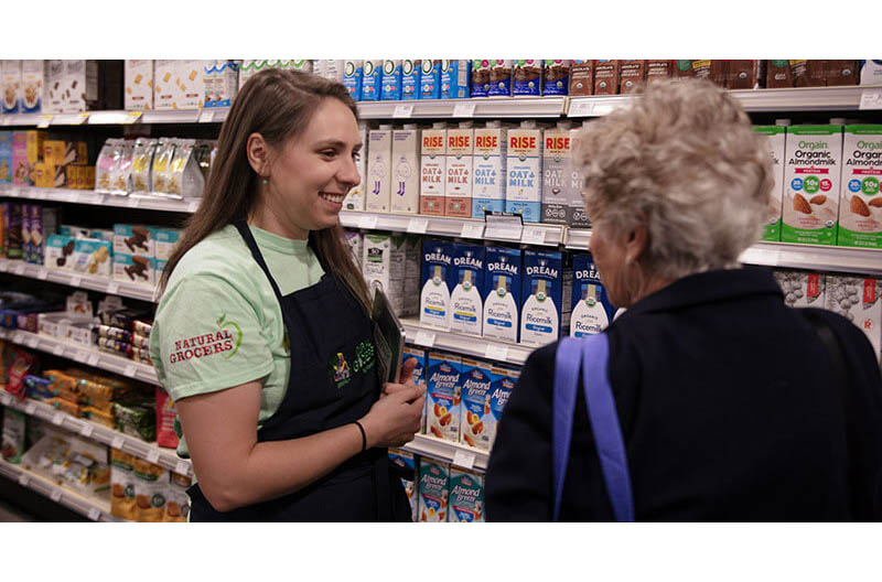 Natural Grocers crew member talking to customer