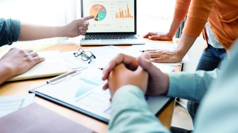 business people surrounding a computer during a meeting