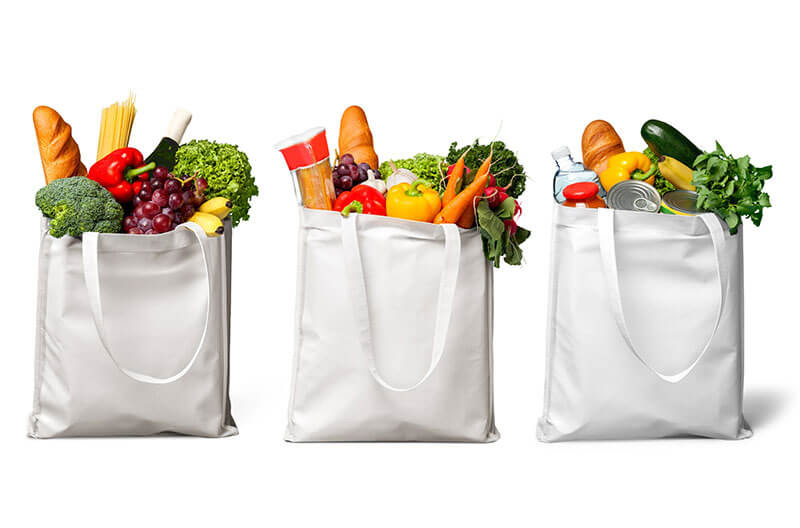 A variety of grocery items in reusable bags to illustrate nutrition policies in Farm Bill