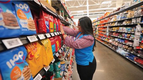 Image of Walmart employee in an aisle with digital shelf labels