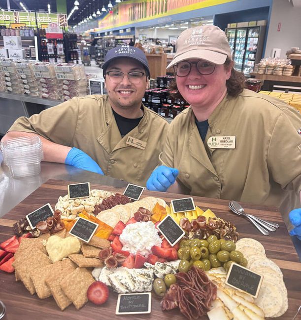 Two Niemann Harvest Market employees with charcuterie board items