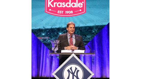 Gus Lebiak, president and chief operations officer at Krasdale Foods, standing at podium on stage to accept New York Yankees Foundation award