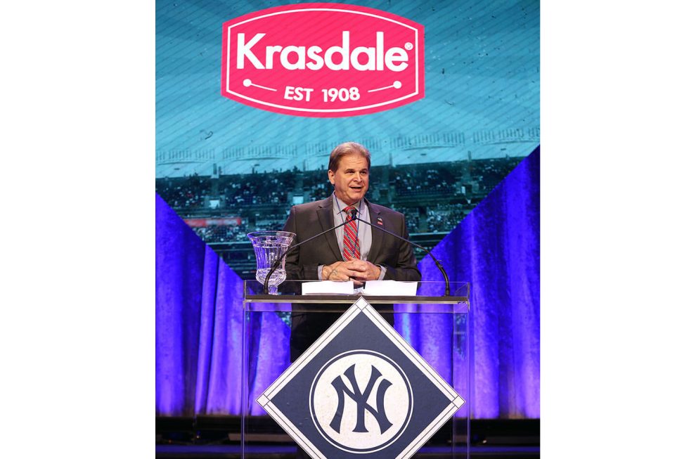 Gus Lebiak, president and chief operations officer at Krasdale Foods, standing at podium on stage to accept New York Yankees Foundation award