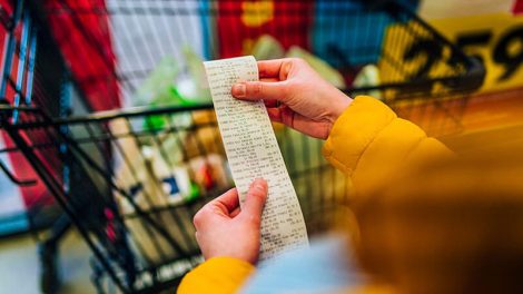 image of lady looking at item pricing on grocery store receipt