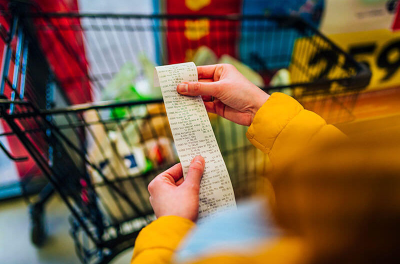 image of lady looking at item pricing on grocery store receipt