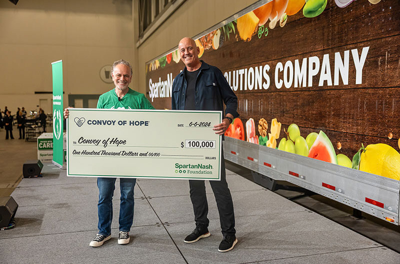 SpartanNash CEO Tony Sarsam presenting check to representative of Convoy of Hope