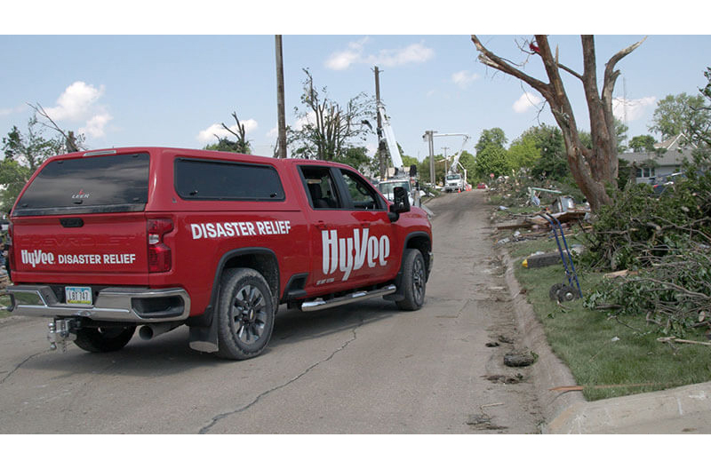 image of Hy-Vee disaster relief pickup truck in storm damaged neighborhood