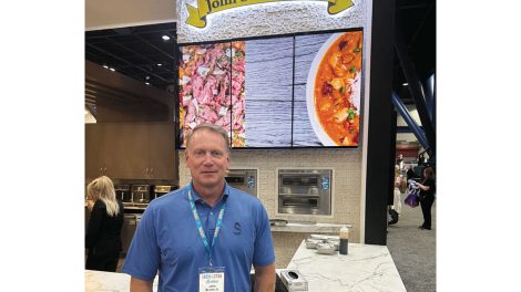 image of John Soules standing in front of John Soules Foods booth