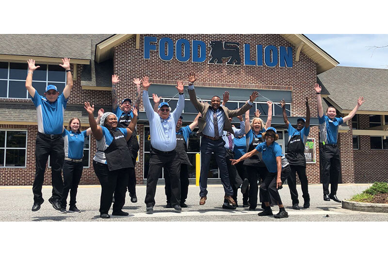 image of group of Food Lion associates jumping in front of store