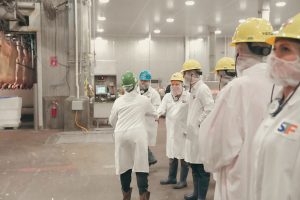 image of STF employee greeting visitors on processing facility floor