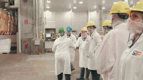 image of STF employee greeting visitors on processing facility floor