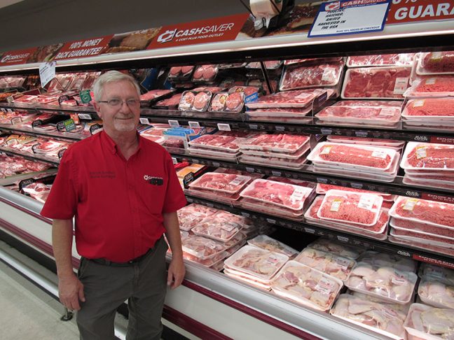 image of Food Giant Enoch Smithey in front of meat case