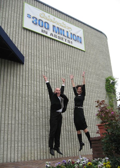 image of Steve Weakley and Donna Simpson leaping into air under banner on side of building