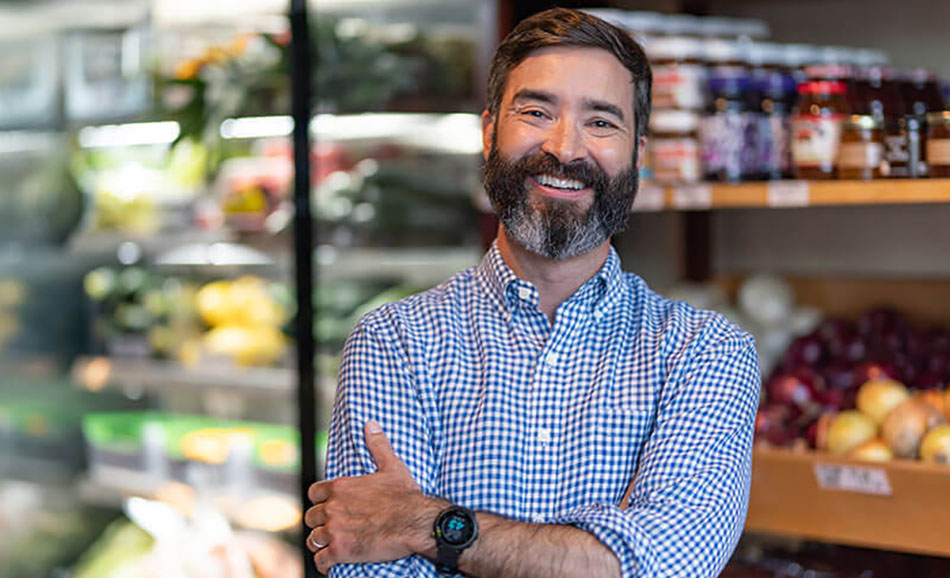 image of Sam Newman standing in front of grocery shelves