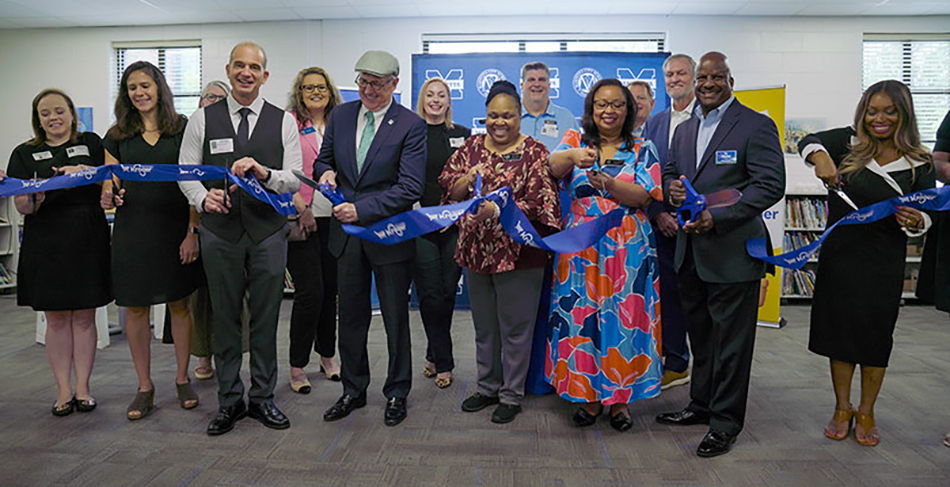 image of group of people from Kroger and MUST Ministries cutting ribbon on new school food pantry