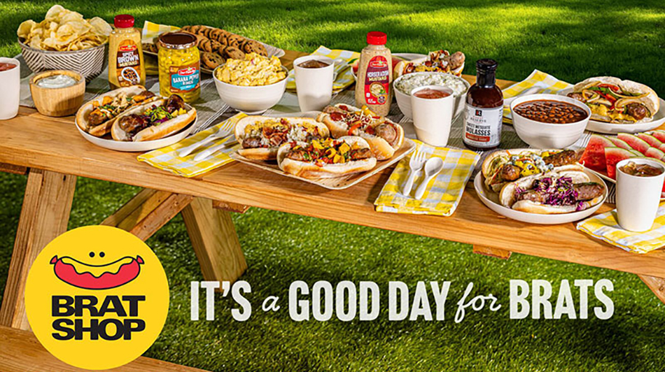 image of picnic table with selection of grilled brats promoting SpartanNash Brat Shop