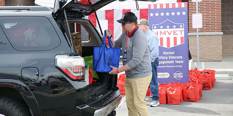 image of volunteer loading groceries into back of SUV at Kent's Market donation event for military families