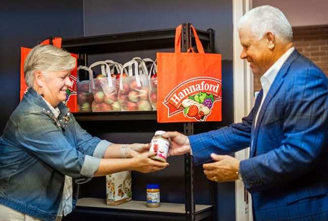 image of Hannaford Supermarkets President Mike Vail and Portland High School Principal Sheila Jepson stocking the first food items at the opening of a new school-based food pantry