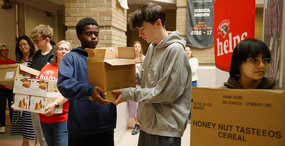 photo of Hannaford associated helping student stock a school food pantry