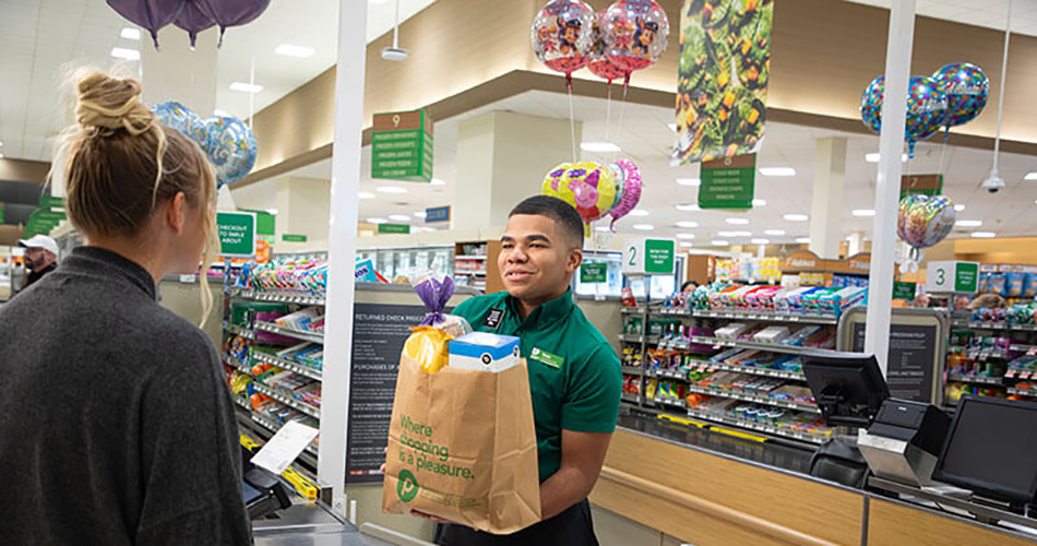 image of Publix associate Izaac Marquez helping a customer at checkout