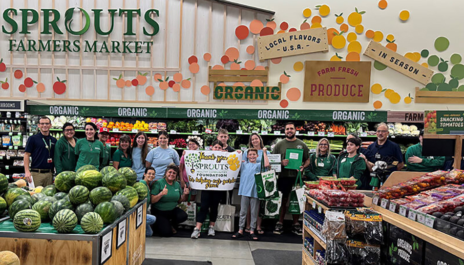 image of Sprouts donation to Caloosa Middle School with group standing in produce department at store