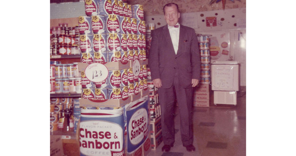 photo of man standing beside coffee display at Certco store in 1930s