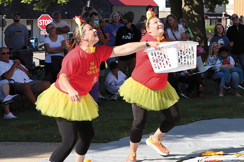 photo of two women in red shirts and yellow tutus holding laundry basket during Chester's Chicken Chuck