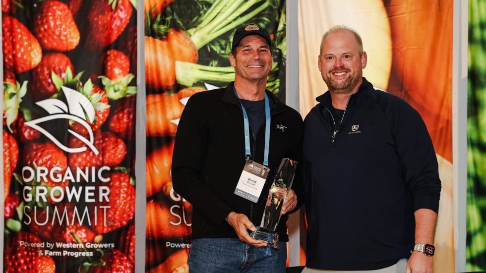 Arnott Duncan of Duncan Family Farms (left) receives the Organic Grower of the Year award from Greg Christensen of John Deere (right).