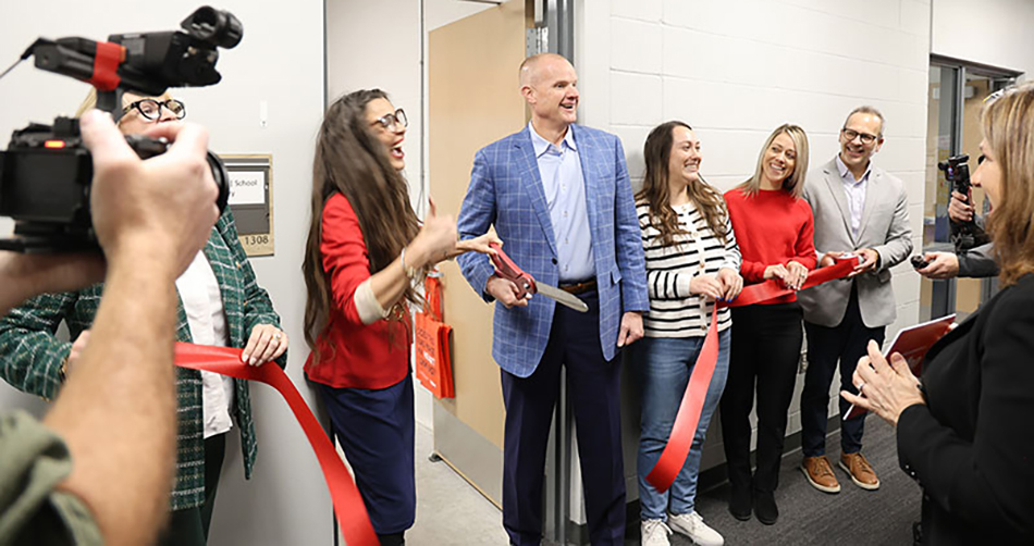 photo of Dr. Deborah Bordenaro, principal at Olmsted Elementary; and Jeremy Gosch, chairman of the board and CEO at Hy-Vee, cutting the ribbon at the pantry