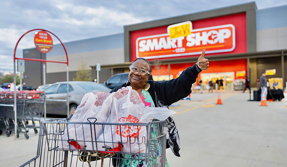 photo of woman pushing cart with Joe V's Smart Shop in background