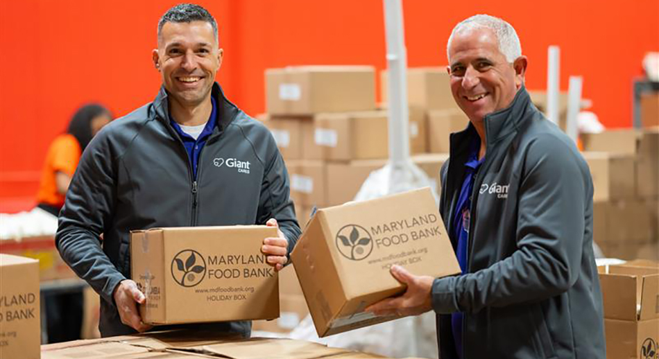 Two Giant Food employees holding boxes of food to be donated to regional food banks for Easter