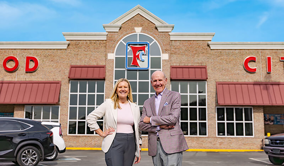 photo of Food City CEO Steve Smith and daughter Katie Penny standing in front of a Food City store