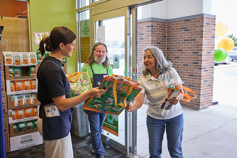 photo of Natural Grocers employees handing out shopping bags