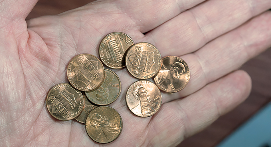 man holding a number of pennies
