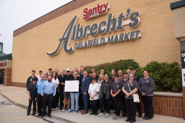 photo of Michelle Harrington with members of her grocery store team in front of store exterior