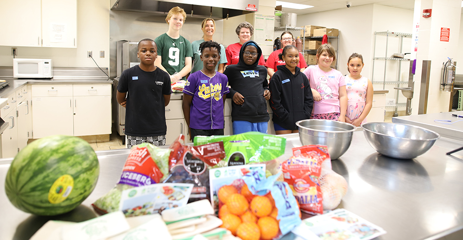 photo of kids at Boys & Girls Club with selection of produce in foreground