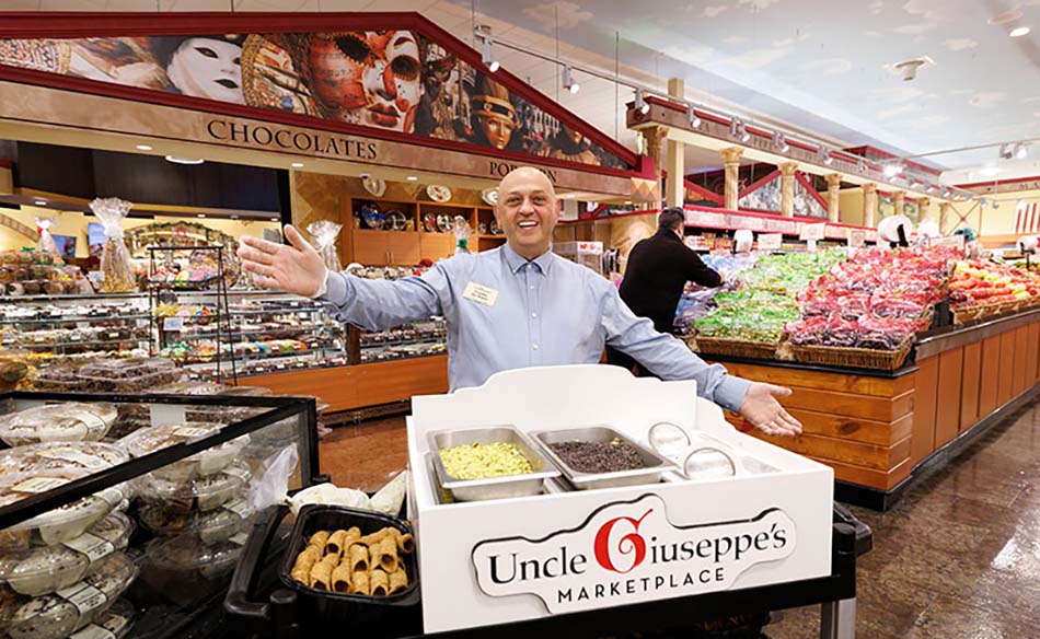 Uncle Giuseppe employee with arms open to welcome shoppers at grand opening